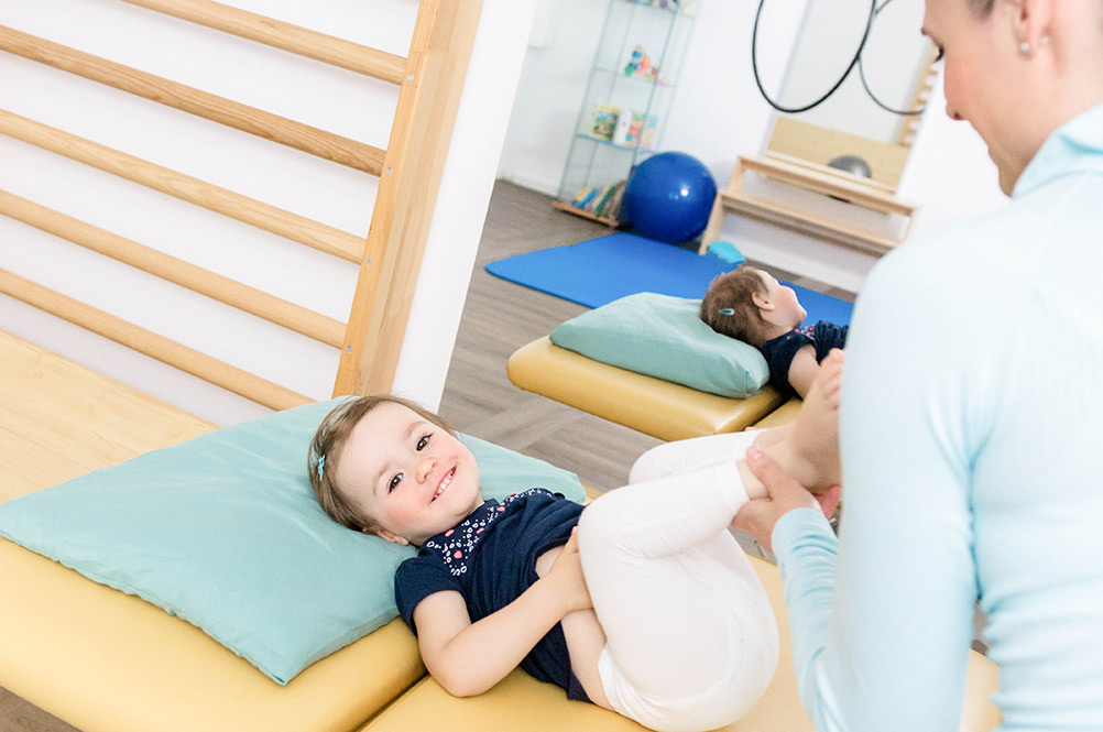 Kind bei physiotherapeutischer Übung auf einer Matratze